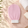 Pink exfoliating bath mitt with white elastic cuff and hanging loop
