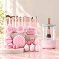 Brush Care Set: the pink 46 piece makeup set next to the pink electric brush cleaner